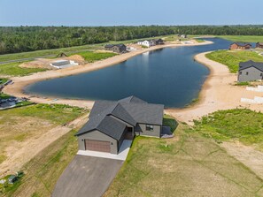 Un quartier résidentiel avec un grand plan d’eau, des maisons et un ciel dégagé.
