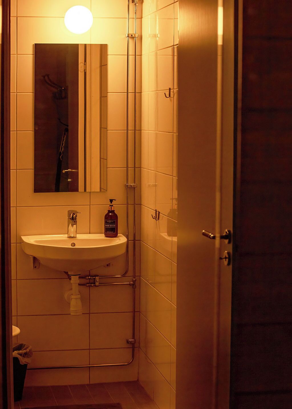 Un baño con un lavamanos blanco, un espejo y una ducha.