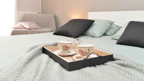 A bedroom with a bed, pillows, a bedside table, and a tray with cups and saucers. - Holiday home with air conditioning and pool (Valbandon)