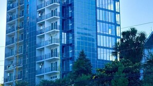 A high-rise building with multiple balconies and a modern glass facade. - Aparthotel Greenhouse (Batumi)