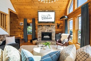 TV connectée, cheminée, livres, écrans d'ordinateur