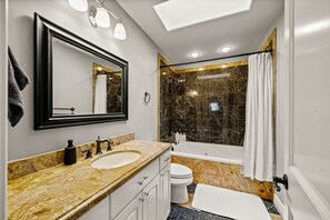 A modern bathroom with a marble vanity, a large mirror, a bathtub, and a shower area. - Maison Monroe. Entertainment basement/ theater/ gym (Denver)