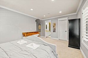 A bedroom with a bed, a desk, and a door. - Maison Monroe. Entertainment basement/ theater/ gym (Denver)