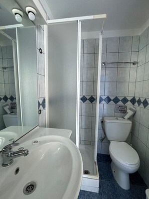 A bathroom with a white sink, a toilet, and a shower enclosure. - Galini Hellenic Hospitality (Alonissos)