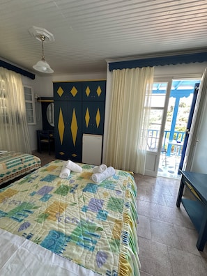 A hotel room with two beds, a wardrobe, a mirror, and a view of the outside. - Galini Hellenic Hospitality (Alonissos)