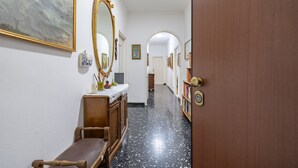 Un pasillo con un banco, un espejo y una puerta.