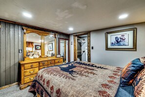A bedroom with a large bed, a dresser, a mirror, and a framed picture on the wall. - Quiet Eagar Retreat Near Lakes, Hiking & Hunting! (Eagar)