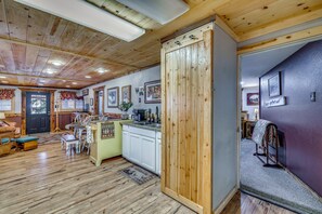 Un interior rústico con pisos de madera, una zona de cocina y un comedor.