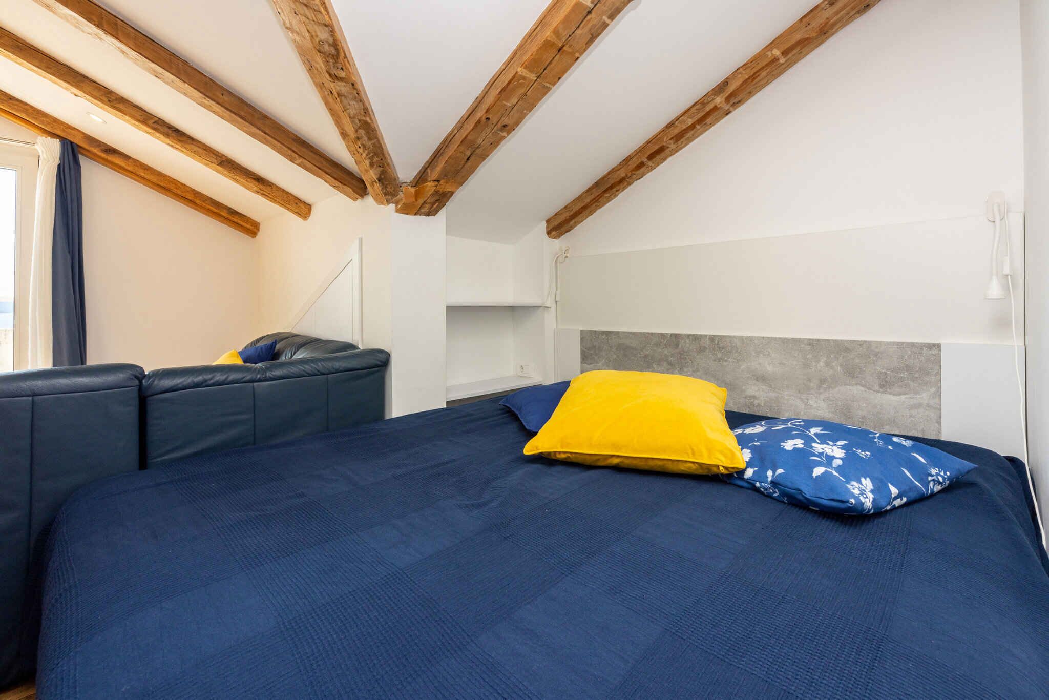 A bedroom with a bed, a sofa, and a headboard.