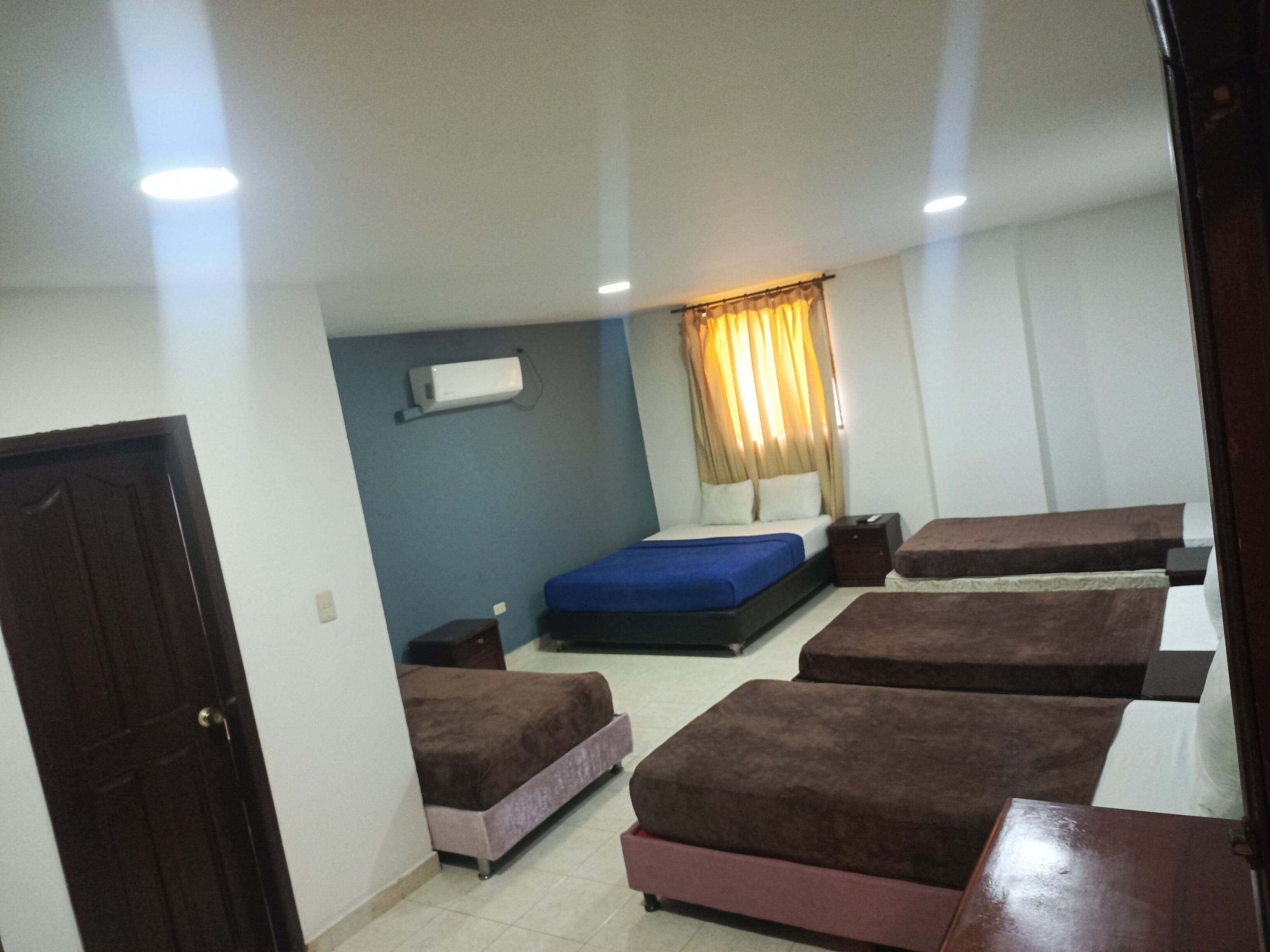A room with a bed, a desk, a chair, and a wardrobe.