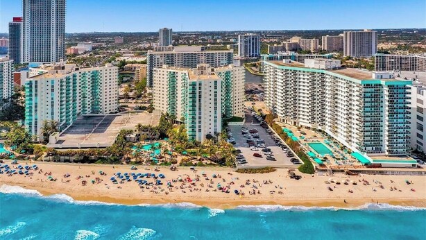 A coastal hotel with multiple high-rise buildings, a beach with umbrellas, and a swimming pool. - Condo w/2 Queen beds and Ocean View | Tides (Hollywood)