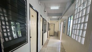 A hallway with doors numbered 202 and 205, leading to rooms. - Sukhum Mega Bangna Guest House By Zuzu (Bangkok)