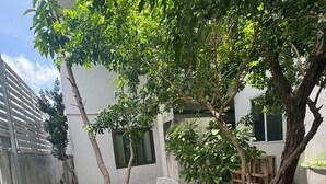 A courtyard with a bench, trees, and a checkered floor. - Sukhum Mega Bangna Guest House By Zuzu (Bangkok)