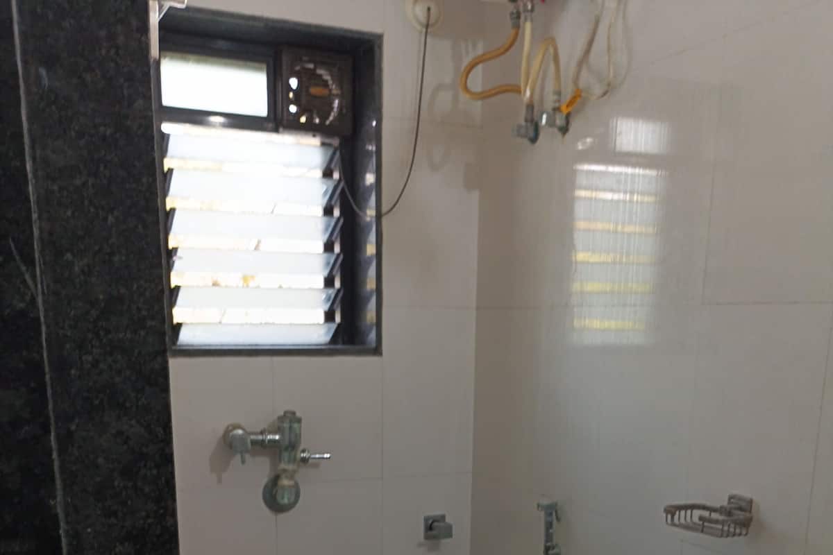 A small bathroom with a toilet, a shower, and a sink.