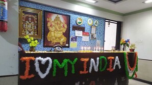 A reception desk with a 'I ❤️ INDIA' sign, framed pictures, and a bulletin board with notices. - Ppmotel alibag  (Alibag)