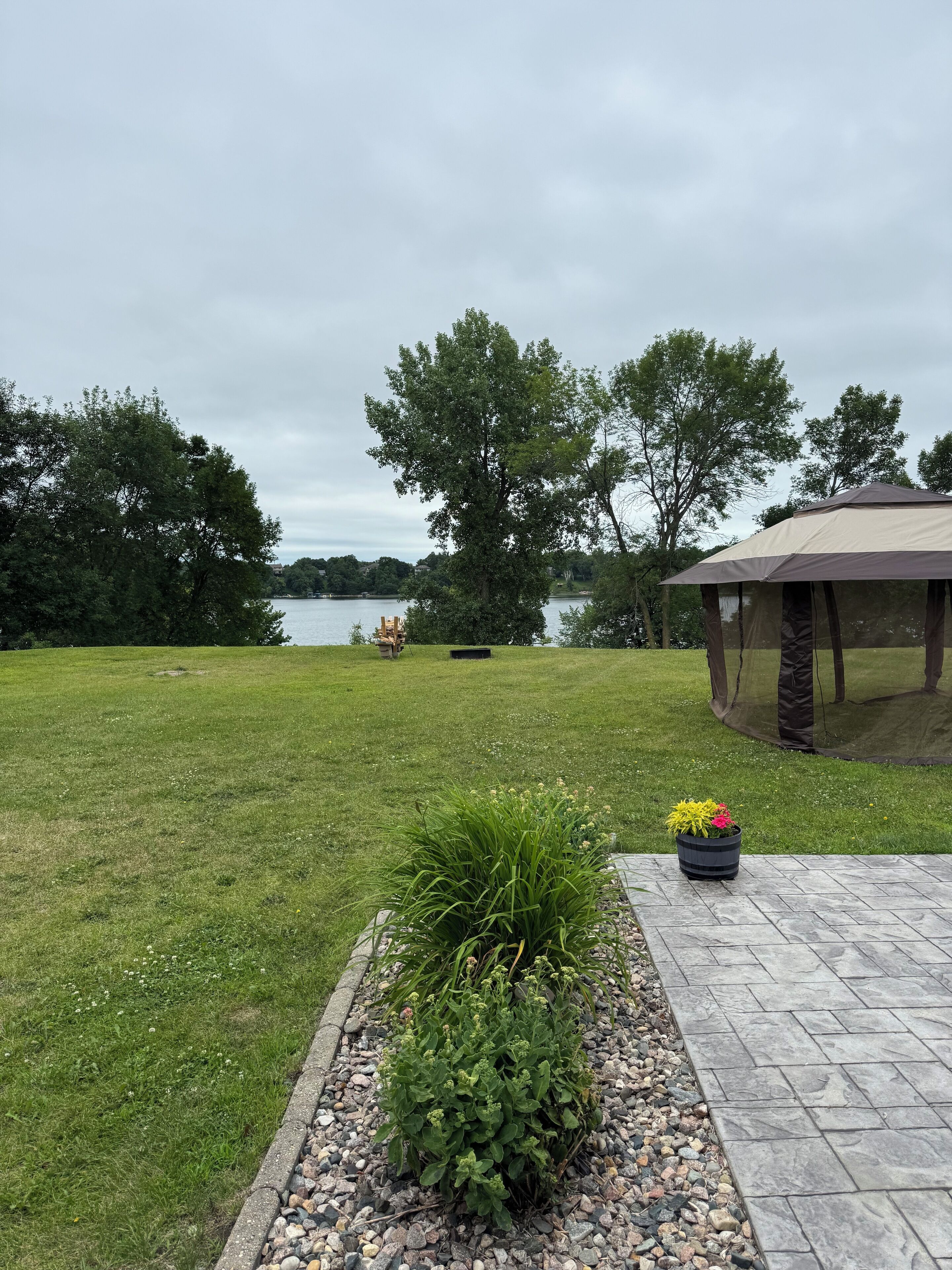 A grassy area with a gazebo and a potted plant.