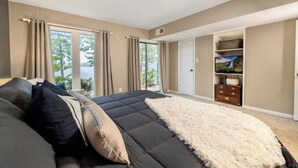 Un dormitorio con una cama grande, televisión y armario.