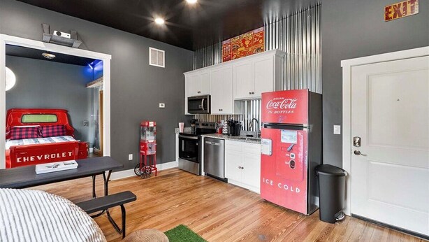 A compact kitchen with a red refrigerator, a microwave, and a sink. - Bourbon Under the Stars Drive-In-Puzzle Room Experience (Frankfort)