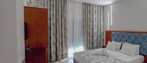 Ein Hotelzimmer mit Bett, Schreibtisch und Kleiderschrank.