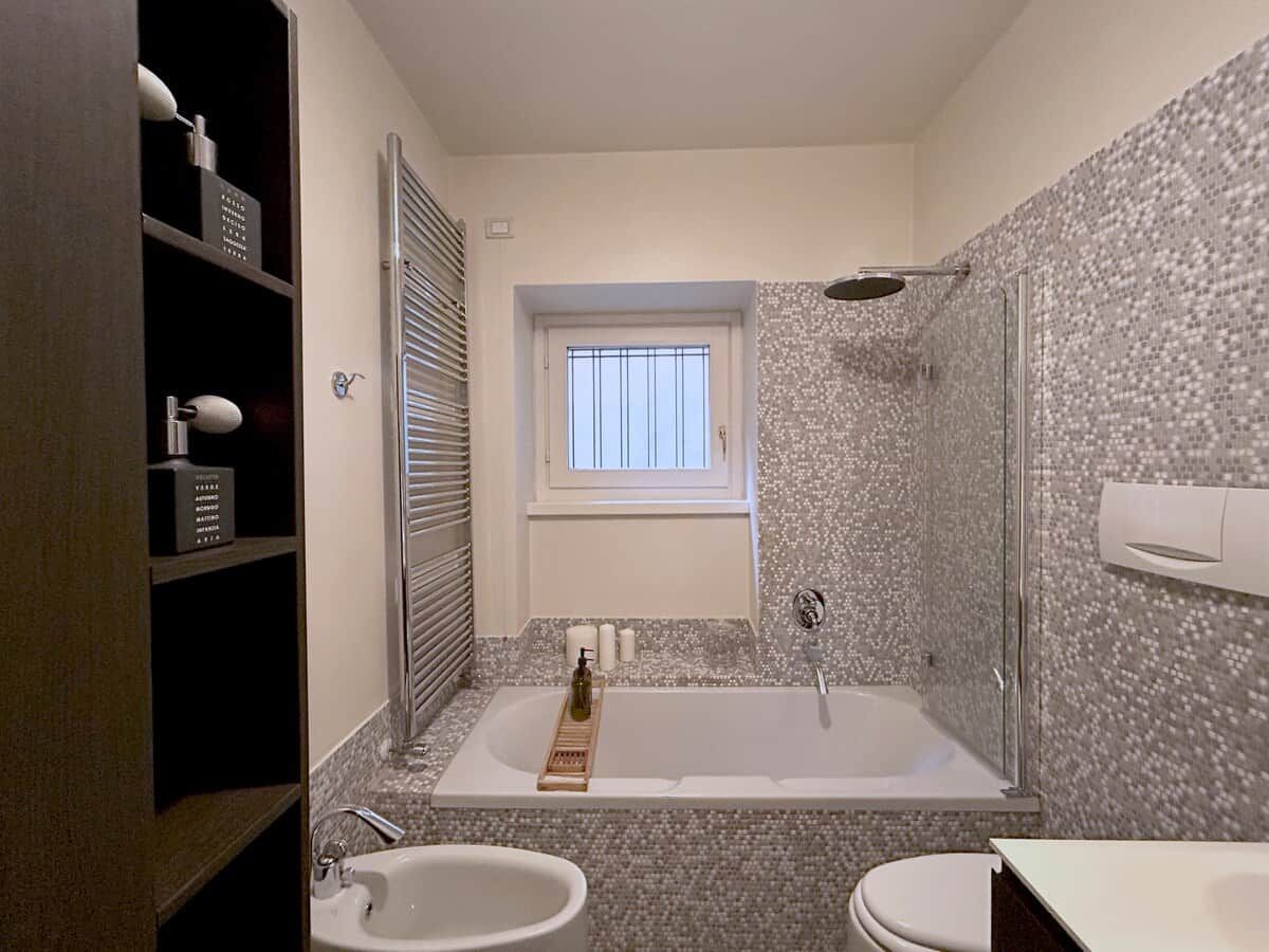 Une salle de bain avec une baignoire, une douche, un lavabo et une fenêtre.