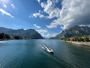 Ein Boot auf einem ruhigen See vor einer Bergkulisse.