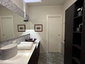 A modern bathroom with a round sink, a large mirror, and a dark wooden cabinet. - COMO mi CASA • Lakefront • Ideal Base for Visiting the Lake (Malgrate)