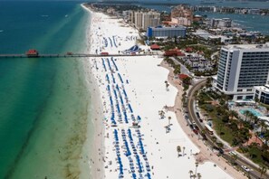 A coastal cityscape with a wide beach, a pier, and several high-rise buildings. - Executive Comfort Stay - Pool - Near HCA & Tampa (Brandon)