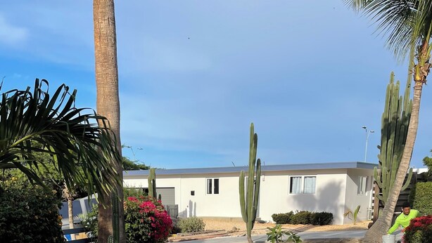 Un bâtiment moderne doté d’un toit plat et d’une seule porte de garage.