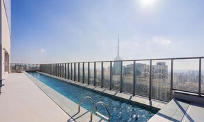A rooftop pool with a glass railing, offering a city view. - Charming, Well-located apt in Paraiso Onp2021 (São Paulo)