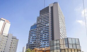 Un edificio alto con varios pisos, ventanas amplias y un diseño arquitectónico moderno.