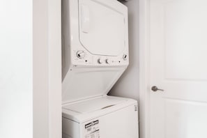 A white washer and dryer unit with a control panel, ENERGY GUIDE label, and a door.