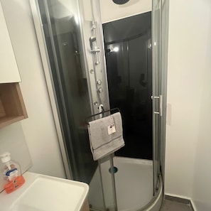 Een douche, handdoeken, zeep, toiletpapier