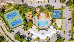 An aerial view of a sports complex with multiple tennis courts, a swimming pool, and a basketball court. - Resort-Style Villa | Pool, Spa & Game Room! (Kissimmee)