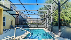 A swimming pool with a glass enclosure, lounge chairs, and a clear blue sky. - 5Br Davenport Home W/ Pool & Private Hot Tub (Davenport)