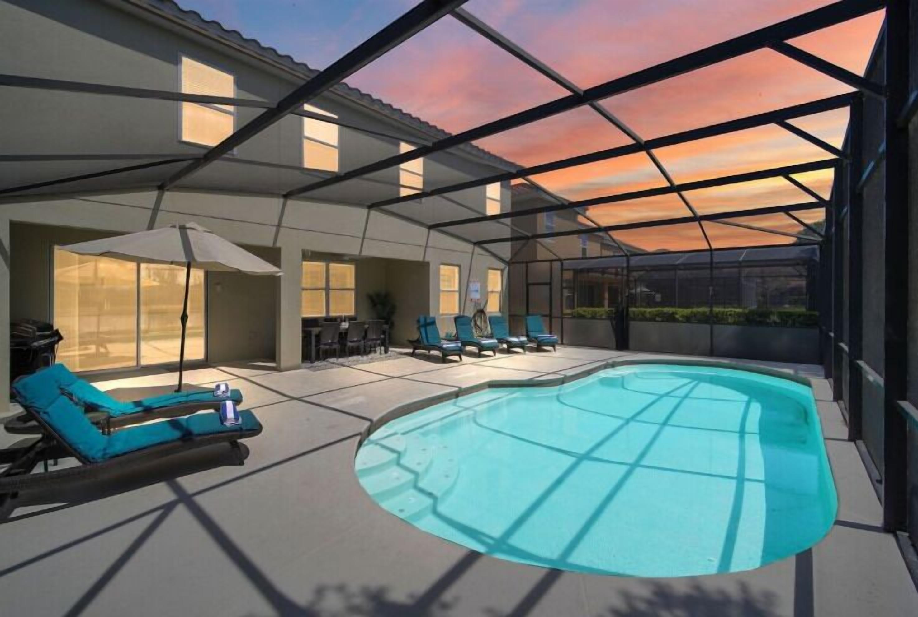 Una piscina al aire libre, sombrillas, tumbonas