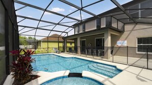 A swimming pool with a glass ceiling, surrounded by a covered patio area. - 6Br Retreat W/ South Pool, Spa & Game Room Fun (Kissimmee)