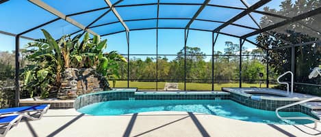 Een buitenzwembad, ligstoelen bij het zwembad