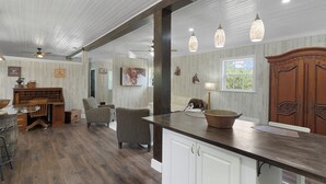 A spacious kitchen with a dark countertop, white cabinets, and pendant lights. - Beyond Charming Luxury Barndominium - Get away without going far away! (Howey-in-the-Hills)