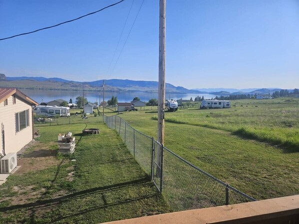 A fenced property with a house, RVs, and a clear view of distant mountains.