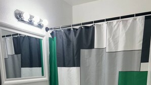 A bathroom with a toilet, sink, and mirror. - The Hideaway (Sacramento)