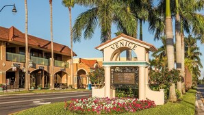 A historic downtown Venice sign with a welcoming message, surrounded by palm trees and a flower bed. - Renovated 1925 Bungalow • Heated Pool • 3BR En-Suite • 2 Mi to Venice Beach (Venice)