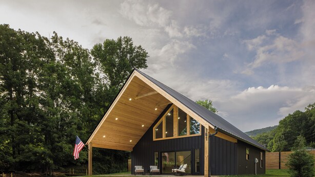 Un bâtiment moderne à deux étages, doté d’un toit en pente, de grandes fenêtres et d’un drapeau américain.