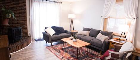 Una sala de estar con sofá, mesa de centro y chimenea.