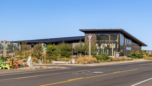 A modern building with a glass facade and a solar panel roof. - OMalley's Ocean Getaway—Nelscott Bch-Dog OK-EV (Lincoln City)