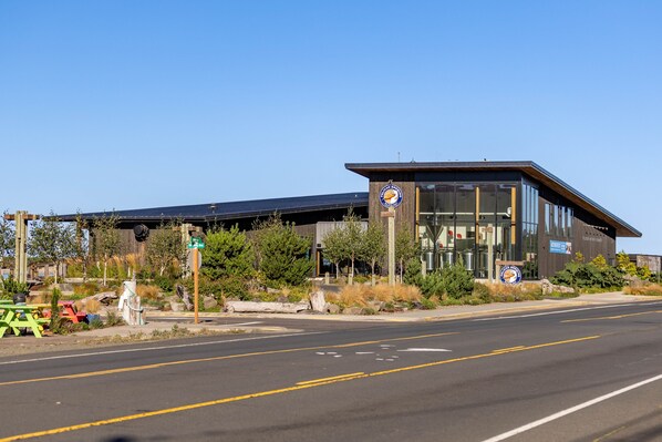 A modern building with a glass facade and a solar panel roof.
