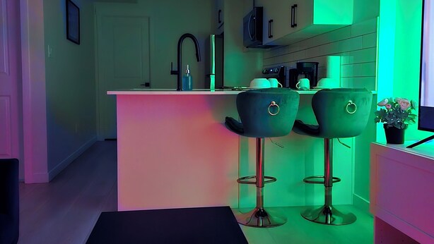 Een moderne keuken met een bar, een eettafel en een barkruk.
