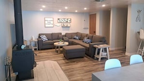 A cozy living room with a fireplace, a sectional sofa, a coffee table, and a dining area. - Lake Seven, Frazee, MN (Frazee)