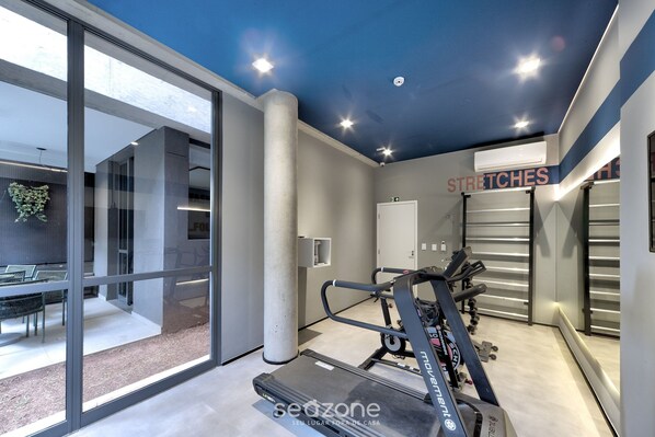 A modern gym with treadmills, weights, and a large window overlooking a landscaped area. - Comfort With Balcony 100m From Puc-pompeia Puq0208 (São Paulo)