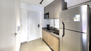Una cocina moderna con electrodomésticos de acero inoxidable, armarios de madera y un microondas.