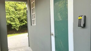 Un ingresso coperto con una porta, una finestra e un sistema di sicurezza a parete.